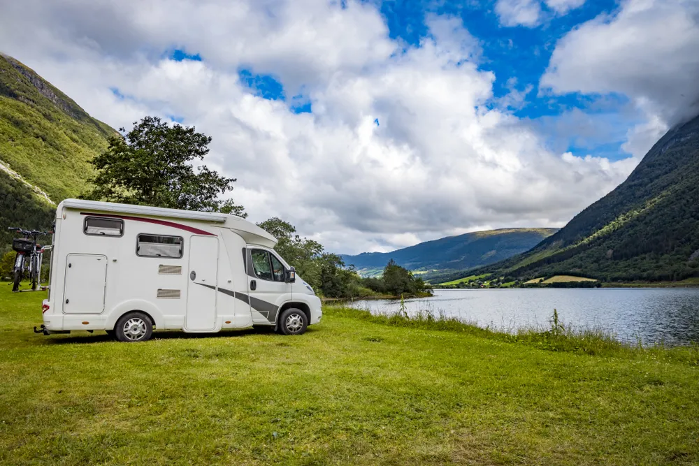 Motorhome parked beside a Norwegian fjord with mountains