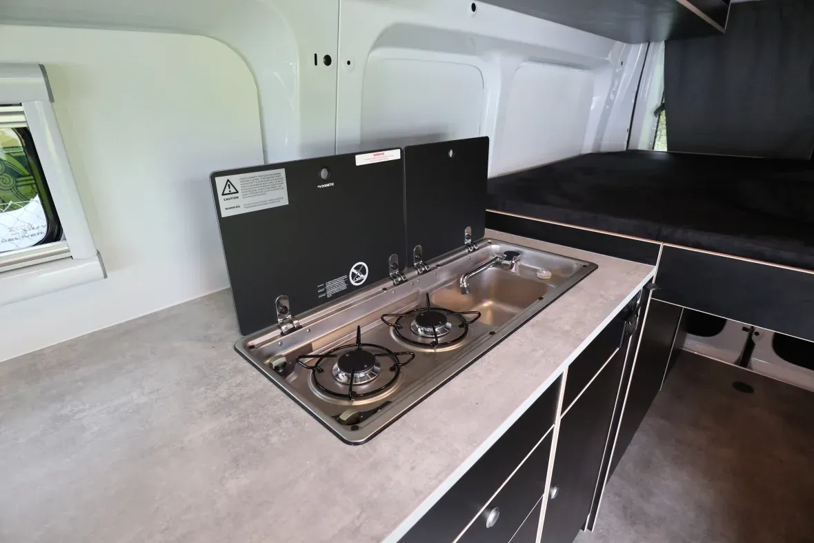 Campervan interior showing stovetop and compact kitchen setup