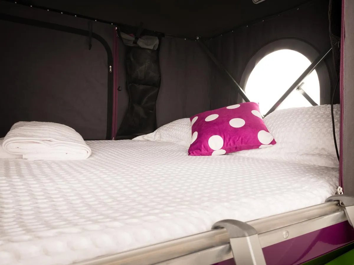 Campervan interior sleeping area with pop-top bed