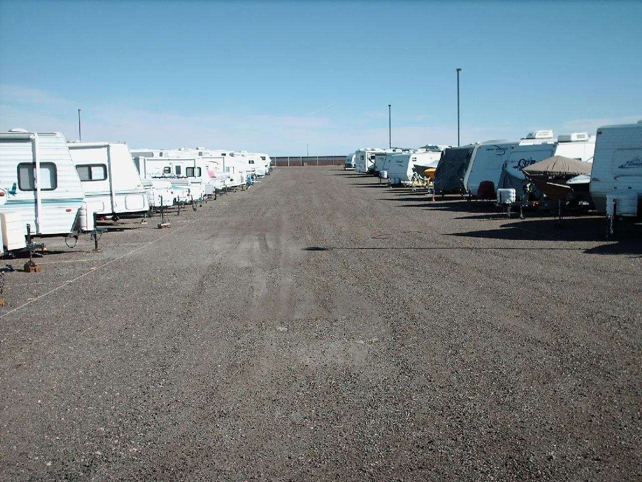 RV storage lot with rows of travel trailers and motorhomes