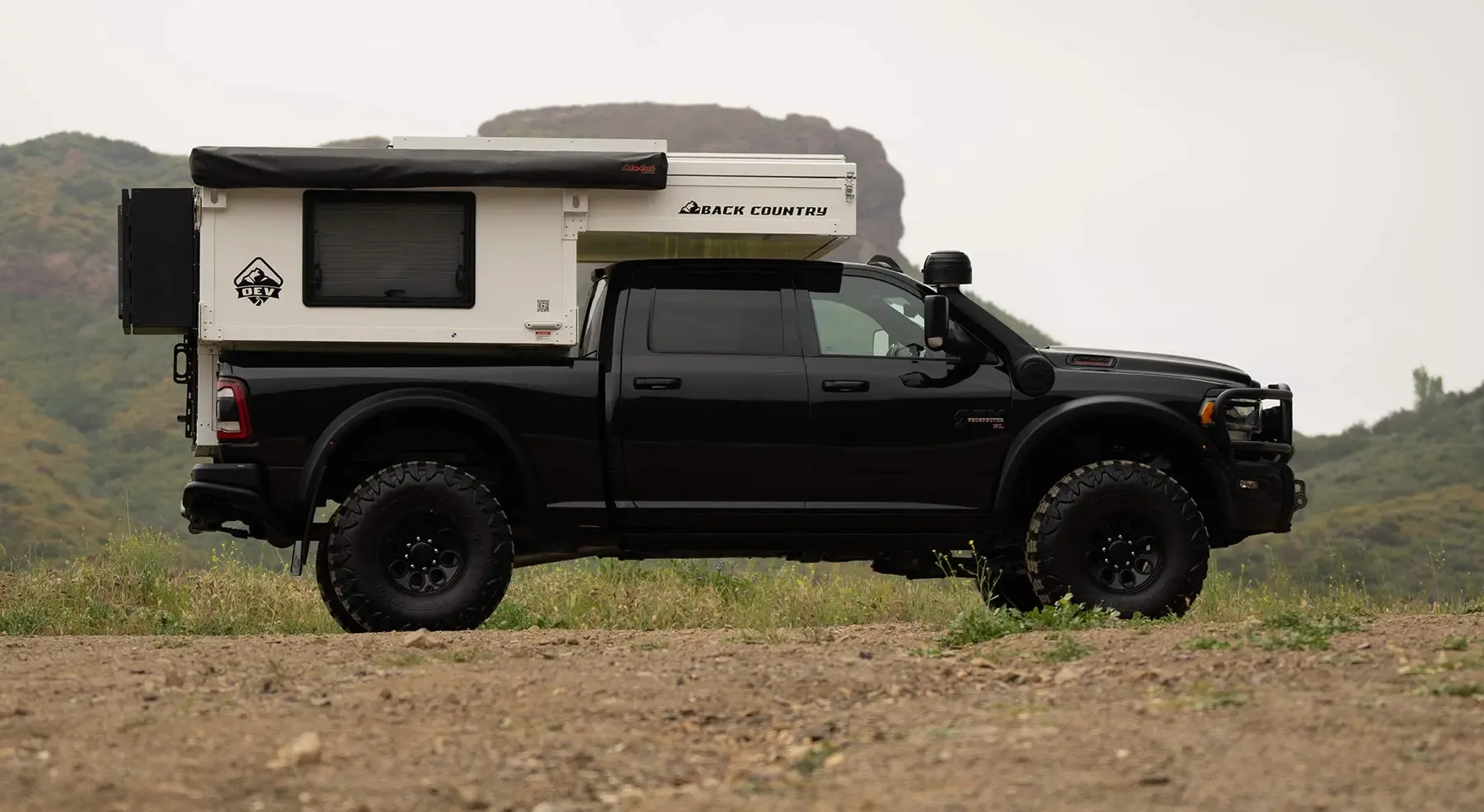 Black truck with back country camper in rugged terrain