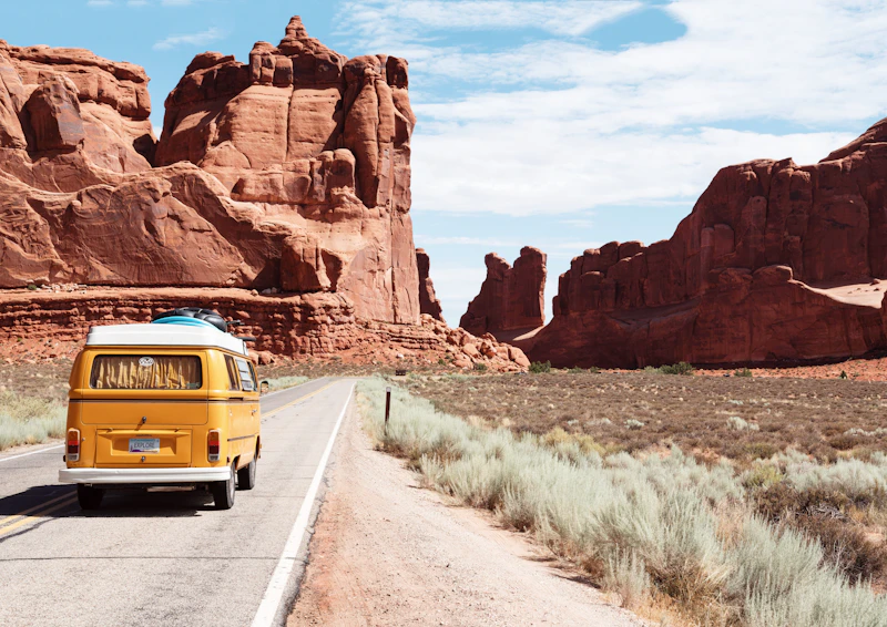 Yellow VW campervan driving through Arches National Park, Utah